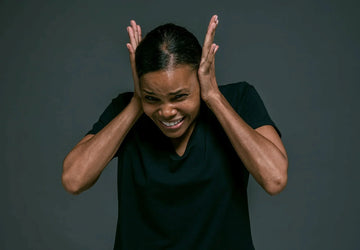 a woman covering her ears with her hands