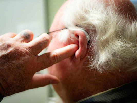 a man pointing a finger towards his ear
